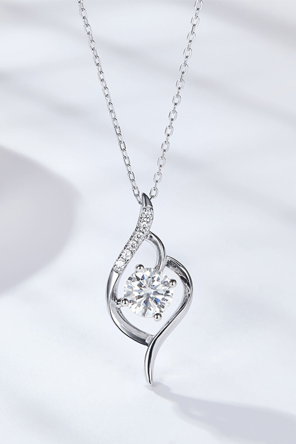 A brilliant 1-carat moissanite solitaire pendant with zircon accents on a platinum-plated 925 sterling silver chain