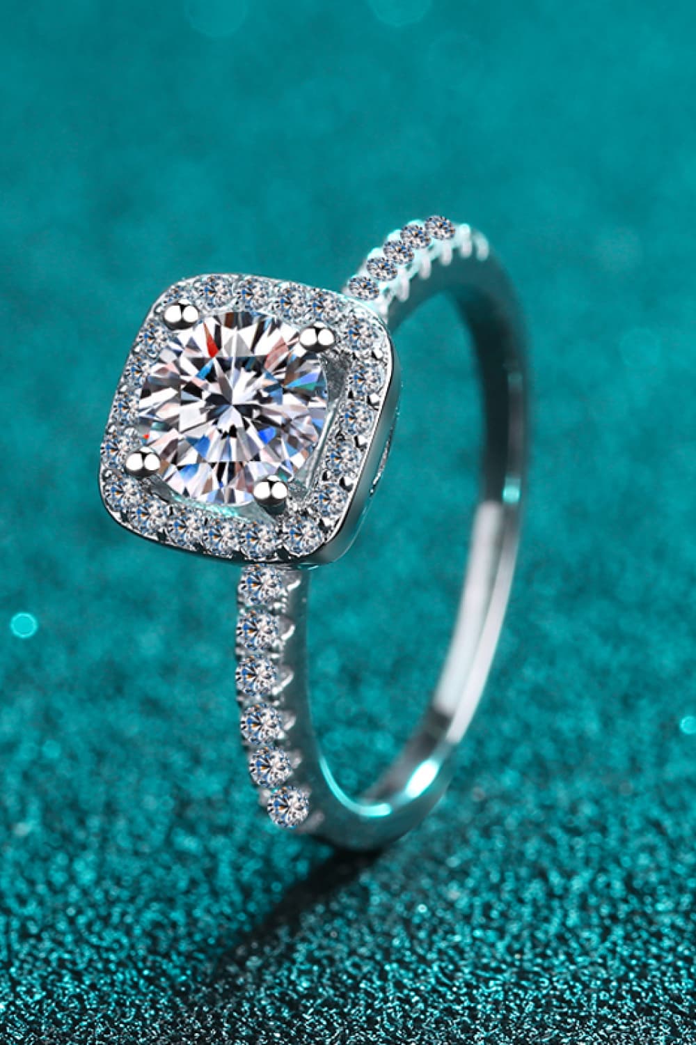 Close-up of zircon accent stones on a rhodium-plated square halo ring.