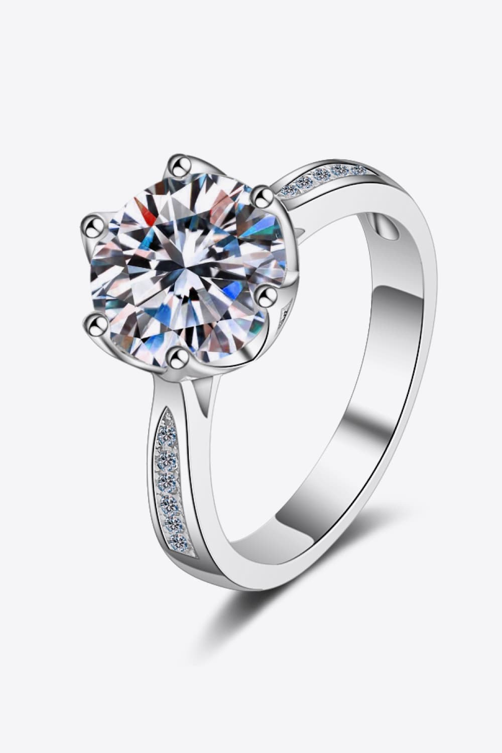 A 3-carat round moissanite center stone with zircon side stones on a rhodium-plated 925 sterling silver band.