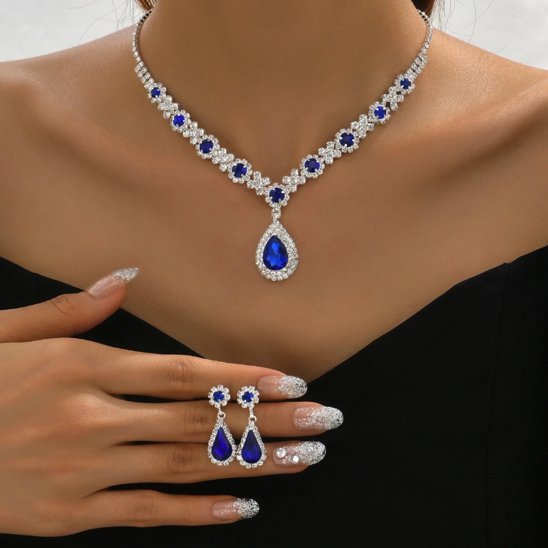 Crystal droplet necklace and matching earring set displayed on a white background.